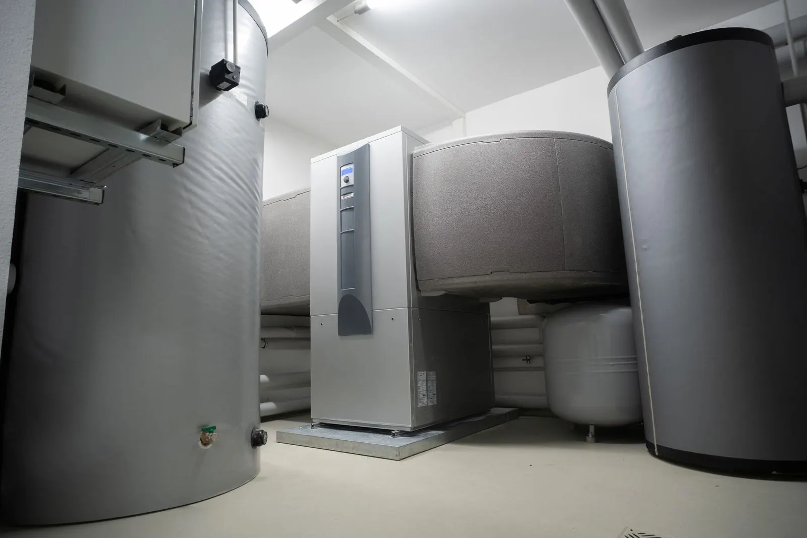 Heizungsraum mit moderner Wärmepumpen-Anlage und Warmwasserspeichern